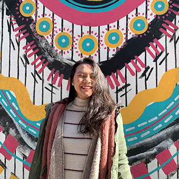 Trang Phan in 2022, standing in front of a nicely painted wall