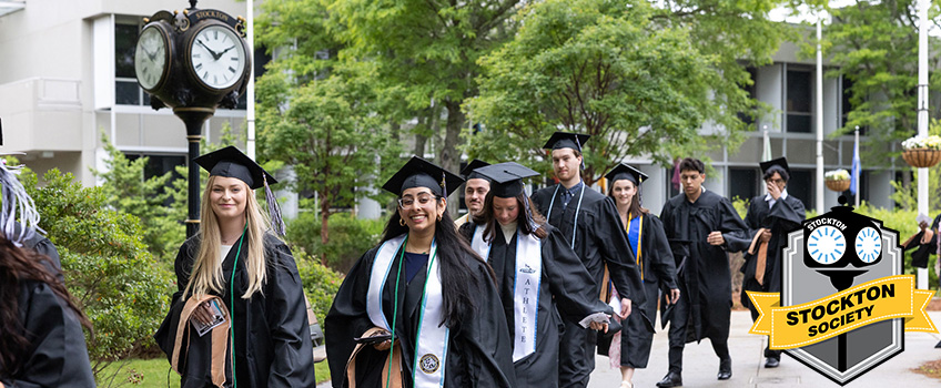 Graduates walking to the Masters/Doctoral Commencement ceremony on the Galloway campus