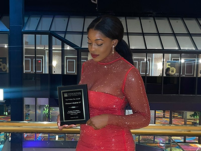 Toyo Aboderin during an event, holding an award