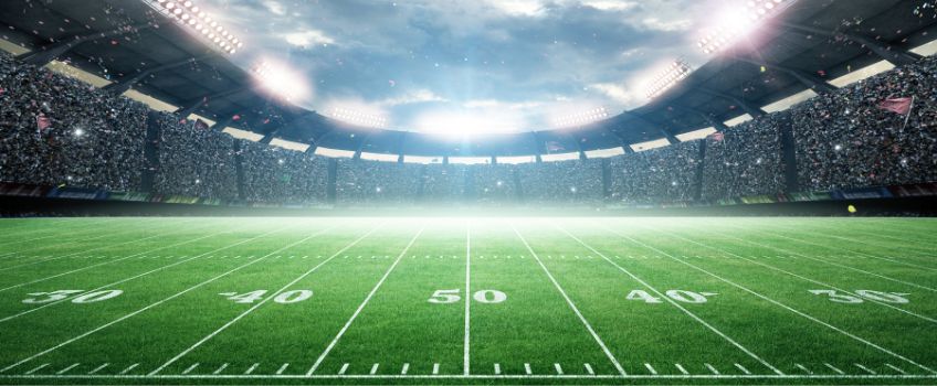American Football Stadium - POV 50 yard line looking up into open sky and glare of stadium lights