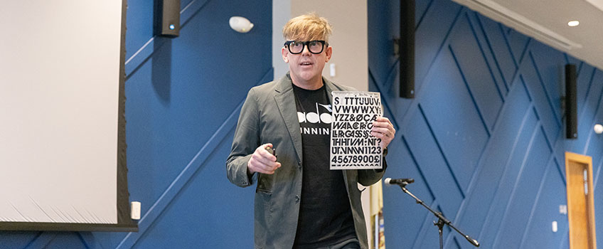 Bryan Poerner '00 speaks to a crowd of faculty, staff and students.