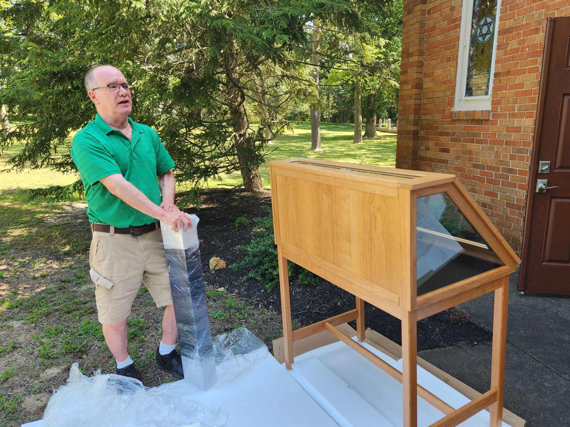 tom kinsella holding installation piece outside chapel