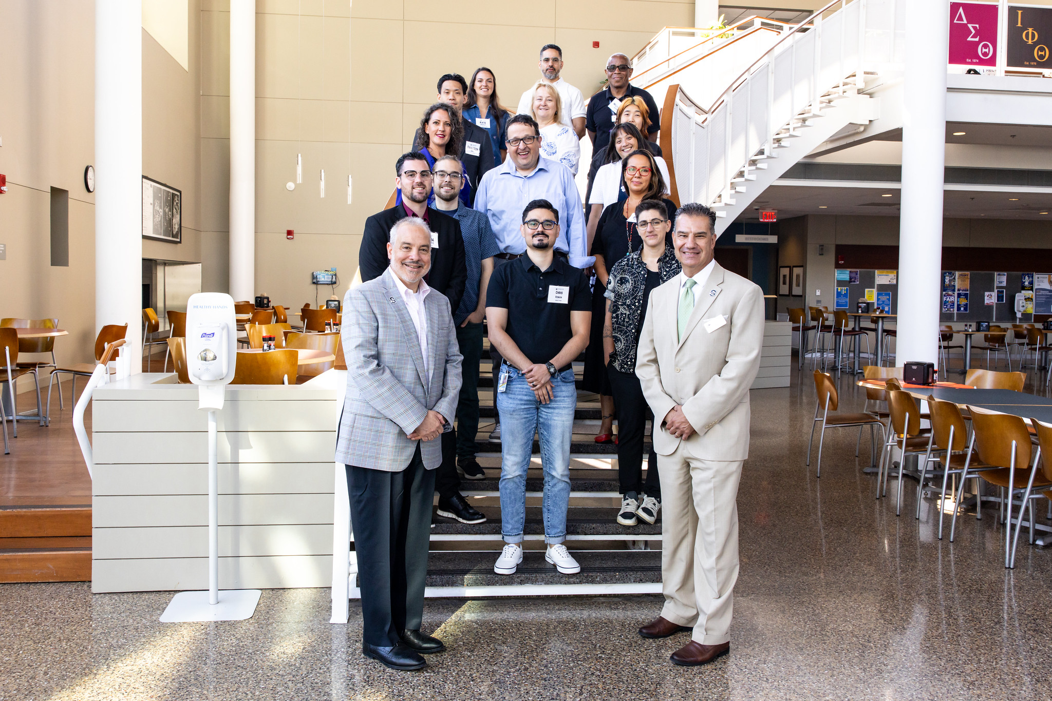 New faculty and President Bertolino and Provost Palladino stand on steps in the Campus Center, Galloway.