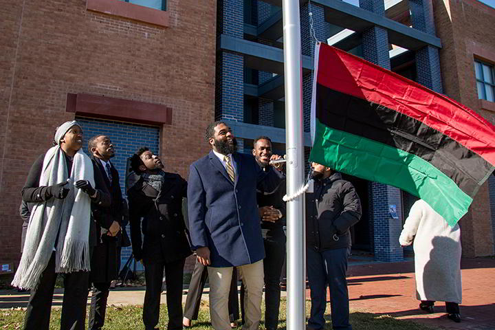 The Unified Black Students Society raises the Pan-African Flag, a symbol of heritage and dignity.