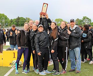 Stockton’s women’s track & field team celebrates  after winning the NJAC Championship in May.