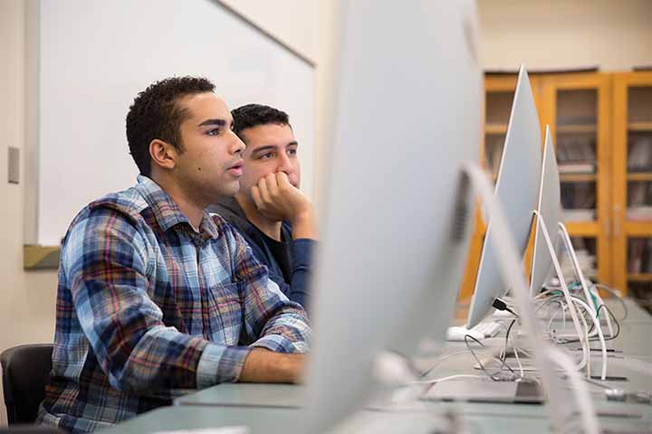 Vizcaino-Martinez and Del Valle looking at a Mac computer monitor