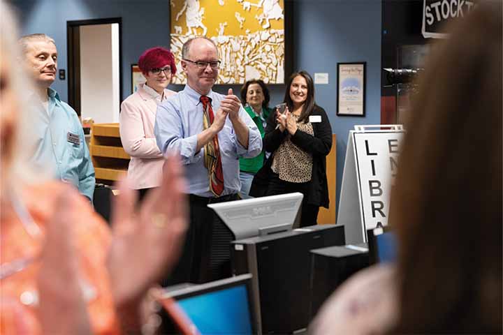 Tom Kinsella claps during a library closing ceremony